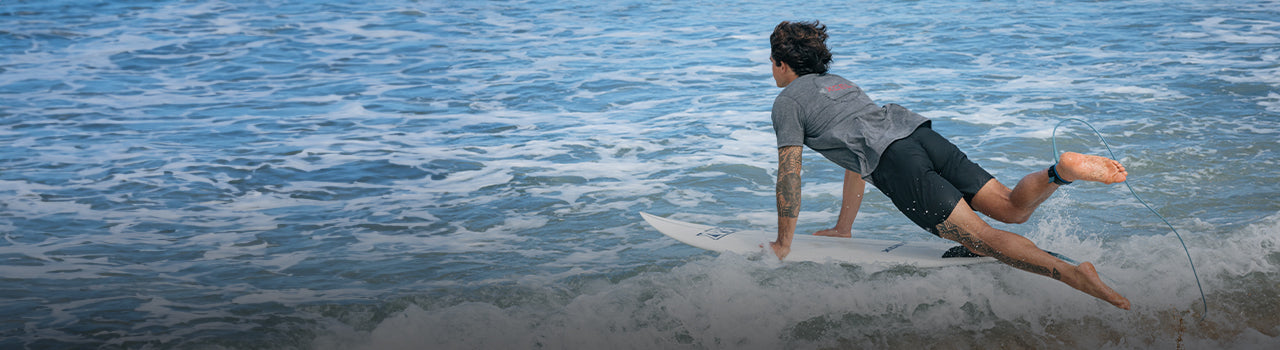 surfer diving into the water with Xcel UV shirt