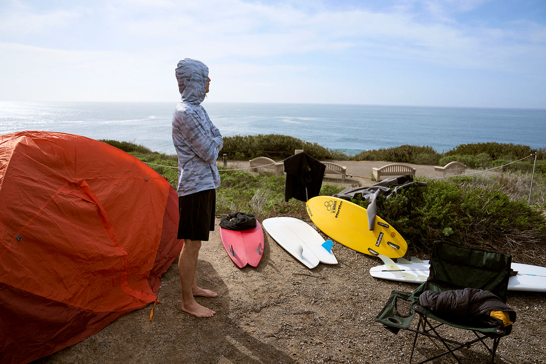 Surfer standing at his campground overlooking the beach in his ThreadX Hooded Pullover Long Sleeve